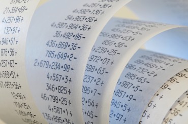 Printing Calculator paper tape rolled up, in blue light